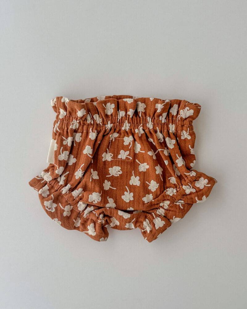 Culetín en muselina de algodón orgánico. Colección Patín. Flores blancas y fondo marrón caramelo